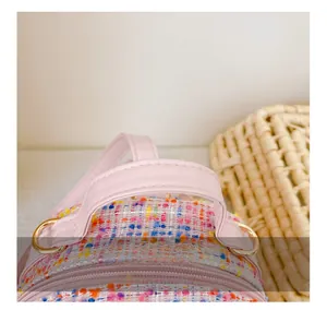 Detailed view of pink tweed kids backpack with leather handle and gold metal hardware