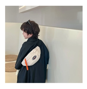 Détail du sac de poitrine en toile pour enfants avec patch SPORT et tirette orange
