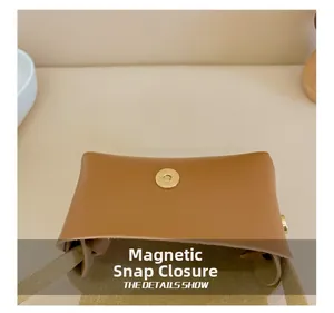 Detail view of the magnetic snap closure on a brown leather mini shoulder bag for kids
