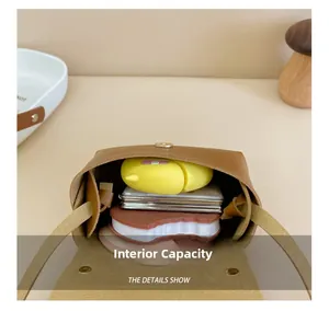 Detail view of the brown leather mini bag's interior storage and magnetic flap closure