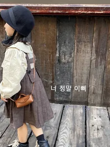 Petit sac bandoulière vintage en cuir marron assorti à une tenue d'automne