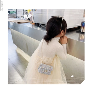 Detailansicht einer blauen Tweed-Miniumhängetasche für Kinder mit goldener Kette