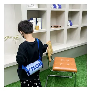 Détail du sac bandoulière enfant bicolore bleu et blanc avec design de lettres TLOP