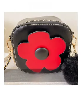 Détail du sac fille en similicuir noir avec applique fleur rouge et coutures contrastées
