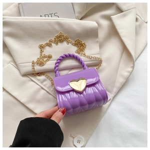 Detail der lila Mini-Gelee-Tasche mit goldenem Herzverschluss und geflochtenem Griff