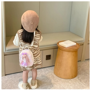 Detail of tweed girls backpack with pearl trim and cute doll accessory in warm home setting