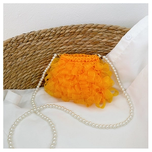 Detailansicht der leuchtend orangen Rüschen-Minitasche mit eleganter Perlenkette