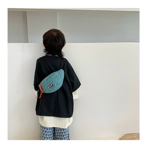 Détail du sac bandoulière enfant bleu canard avec écusson sport et cordon zip orange vif
