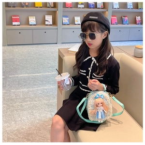 Detail of girls' cream pearl crossbody bag with mint strap and cute princess doll accessory