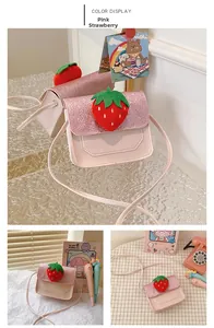 Detail of pink PU leather girls mini crossbody bag with sequin lid and plush strawberry
