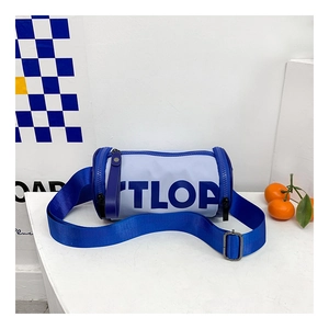 Détail du sac cylindrique avec lettrage TLOP bleu et large bandoulière en nylon