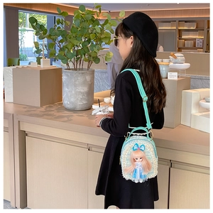 Detail view of light blue tweed crossbody bag for girls with cute doll ornament and strap