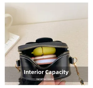 Détails montrant la capacité intérieure du mini sac à bandoulière rond noir pour fille