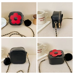 Détail petit sac noir pour filles avec fleur rouge, chaîne dorée et pompon en peluche
