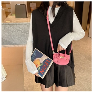 Détail du mini sac à bandoulière en cuir PU rose avec texture grainée et fermoir rotatif en métal
