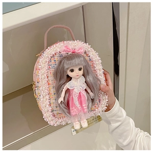 Detail of pink tweed girl bag with pearl trim, lace edge, and a cute cartoon doll ornament