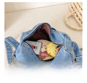 Detail showing blue denim bag interior with metal zipper and brown fabric lining