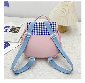Dettaglio dello zaino rosa per bambini con patta a quadretti blu e spalline