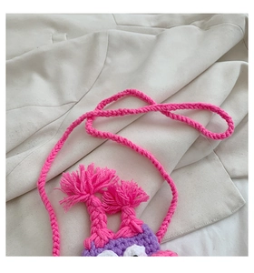 Détail de mini sac monstre en tricot fait main avec laine rose fuchsia et violette