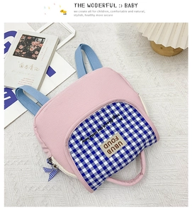 Dettaglio dello zaino bimbi in velluto rosa con tasca a quadretti blu e ricami cuciti