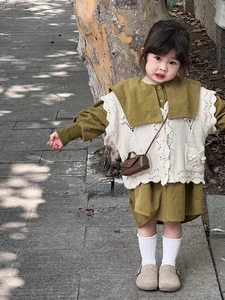 Détail de la robe moutarde pour bébé avec gilet au crochet et petit sac à bandoulière brun