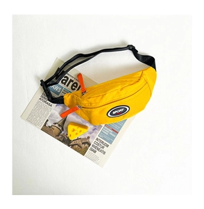 Détail d'un sac de poitrine en toile jaune pour enfant avec bandoulière réglable