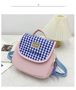 Dettaglio dello zaino rosa per bambini in tela con patta a quadretti blu e ricamo carino