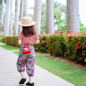 Mädchen-Sommeroutfit mit rot gestreiftem T-Shirt, Blumenhose und einer Herz-Minitasche