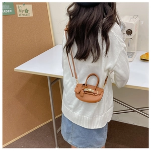 Détail d'un mini sac demi-lune en cuir PU marron avec breloque pétale et fermoir