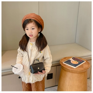 Girl's retro vintage look with knit cardigan and brown mini crossbody shoulder bag