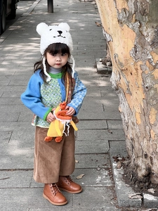 Detail of a handmade knitted duck bag paired with a child's cozy autumn knitted outfit