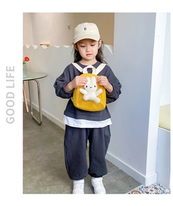 Detail of yellow canvas backpack for girls with 3D plush bunny and white shoulder straps