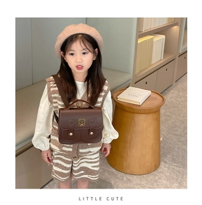 Detail of child wearing a brown PU leather vintage schoolbag with cute bear embroidery