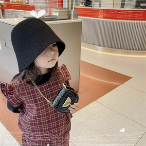 Girl's outfit featuring a black cloche hat and crocodile pattern mini saddle chain bag