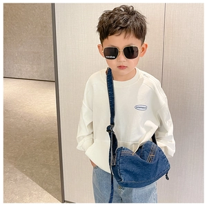 Kids denim crossbody bag with yellow stitching and adjustable strap shown on child model