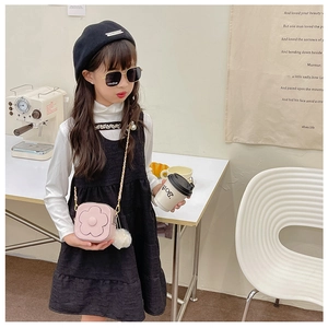 Détail du petit sac rose pour enfant avec fleur, chaîne en métal et pompon doux