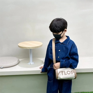 Combinaison en jean pour enfants avec sac cylindrique en toile en décor extérieur