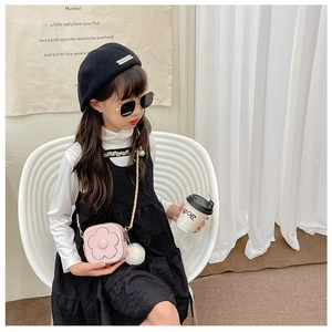 Détail du sac floral rose avec chaîne en métal sur une tenue de fille élégante