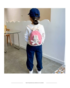 Pink canvas toddler backpack with plush bunny detail shown on a child model's back