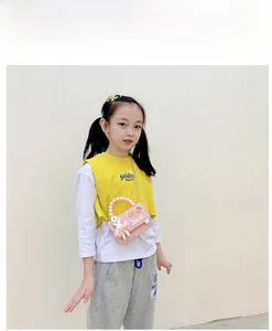 Détail du sac à carreaux rose pour enfants avec poignée en perles et lapin en peluche