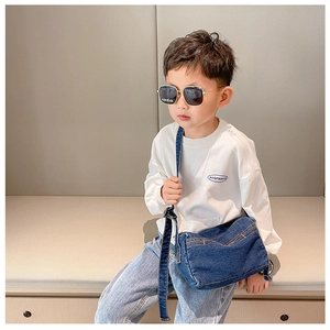 Detail of dark blue denim kids crossbody bag with yellow stitching and adjustable strap
