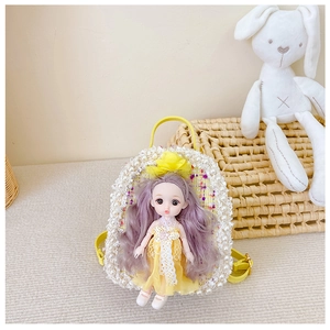 Close-up of yellow girl's mini backpack with pearl lace and cute 3D doll ornament detail