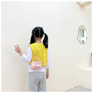 Détail du sac enfant en tweed rose avec poignée en perles et breloque lapin
