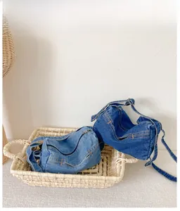 Detail of light and dark blue denim crossbody bags with zipper on woven tray