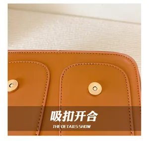 Detail of caramel leather backpack showing dual magnetic snap button closures and stitching