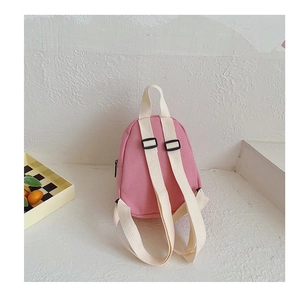 Rear view of a small pink canvas backpack for kids featuring adjustable straps and carry handle