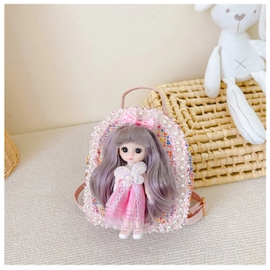 Detail of pink tweed kids handbag with doll ornament and pearl trim accents