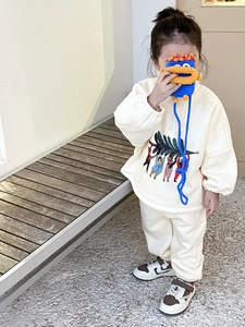Détail rapproché du sweat-shirt crème pour enfants avec motif de Noël animé coloré