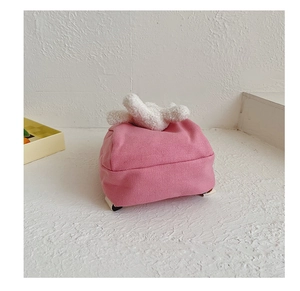Close-up of pink canvas toddler backpack featuring white plush rabbit ears detail