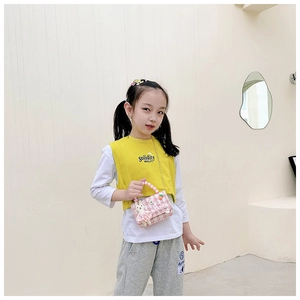 Détail du mini sac à carreaux roses avec poignée perle et lapin sur un mannequin enfant